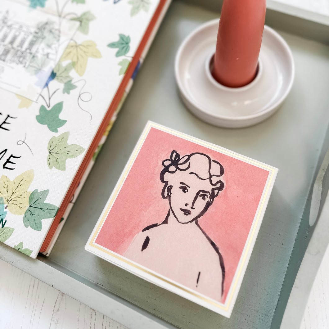 Luxury Square Matches on a green tray with a handmade candle holder , pink stubby candle and a book on home design