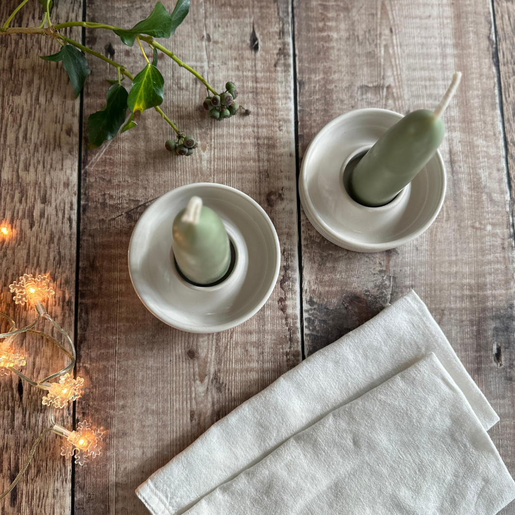 A pair of handmade candle holders in Linen with stubby candles from Wax Atelier